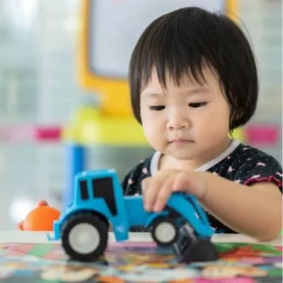 Young girl playing with a tractor